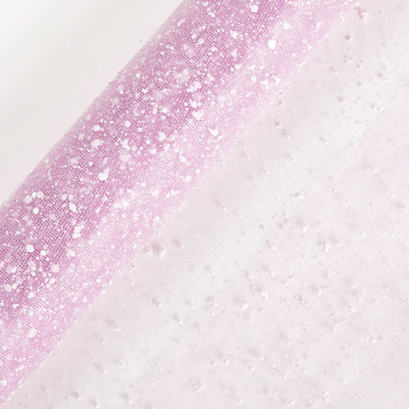 Gradient fabric with pink glittery texture on one side transitioning to white on the other, on a light gray background.